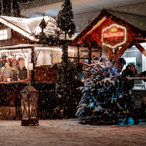 Glühweinstand im Schnee mit einem Tannenbaum