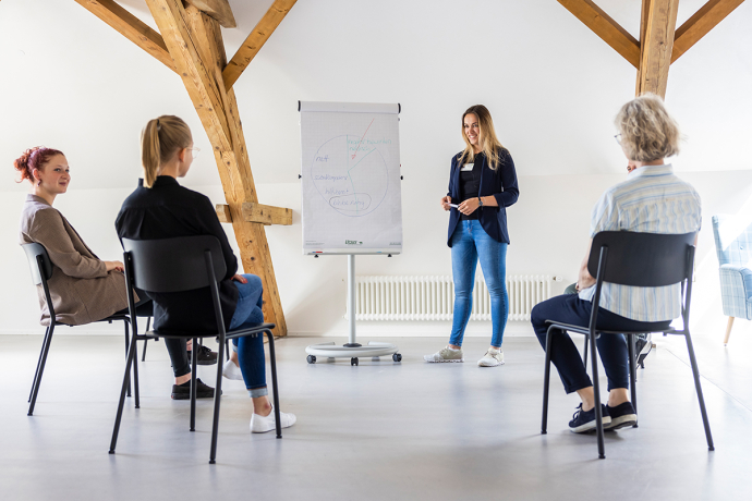 Workshop Mental Health (© PDGR) Eine Gruppe redet im Plenum mit Workshop-Leiterin