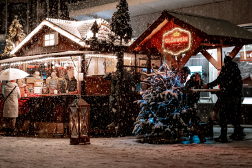 Glühweinstand im Schnee mit einem Tannenbaum