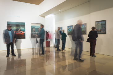 Besucher:innen betrachten Kunstwerke im Forum Würth Chur. Durch die Langzeitbelichtung wirken einige Personen in Bewegung verschwommen, was der Szene eine lebendige, fast träumerische Atmosphäre verleiht.